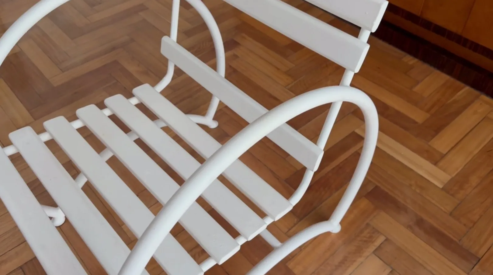 Antique garden armchairs with a simple design, light wood background.