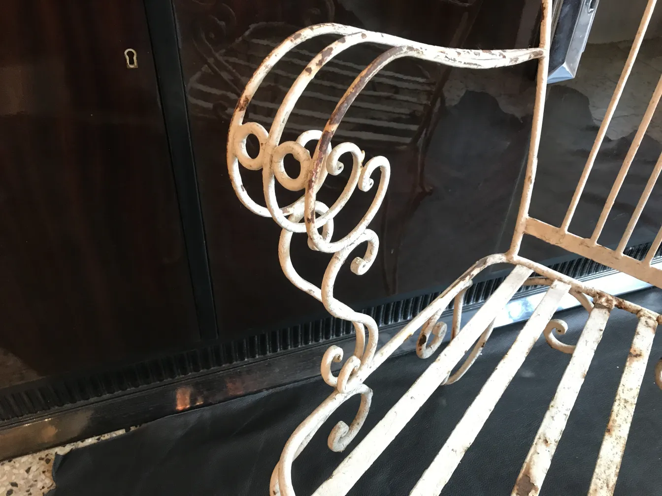 Close-up view of an antique garden armchair with ornamental details