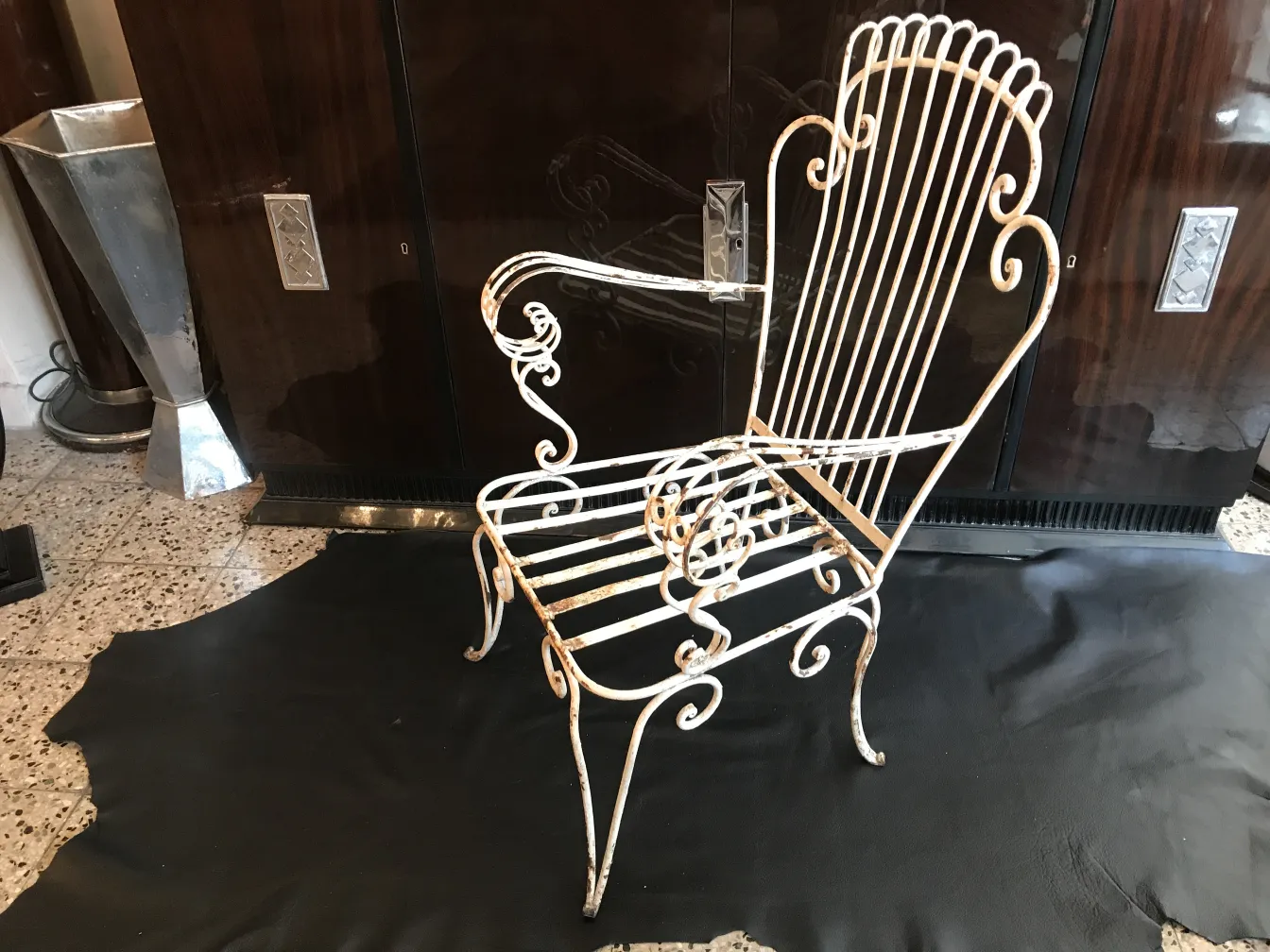 Four antique garden armchairs with elegant design in a classic setting.