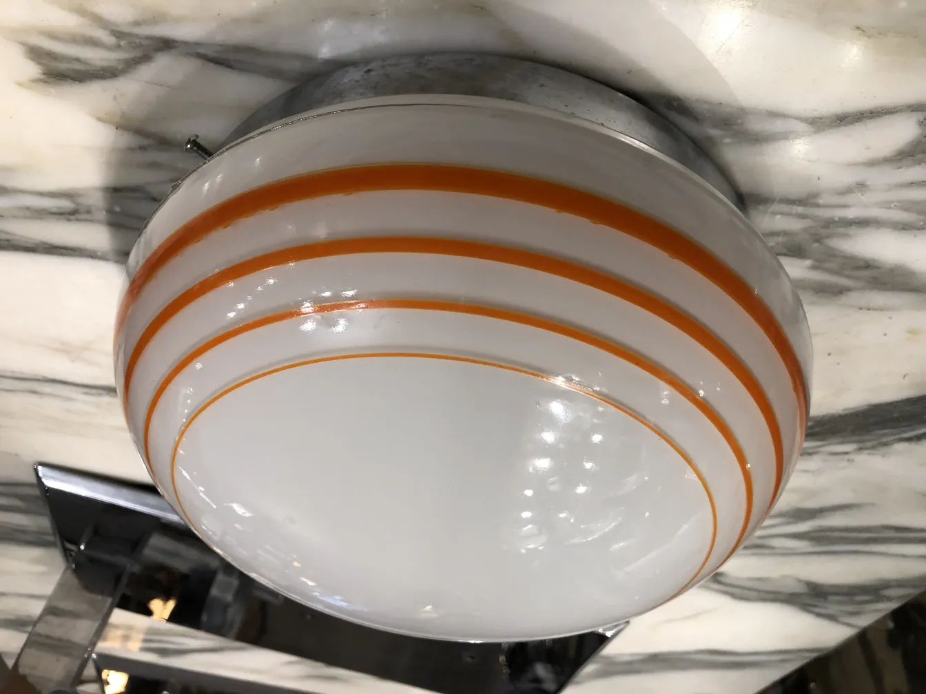 Three antique ceiling lights with orange details, illuminating the area