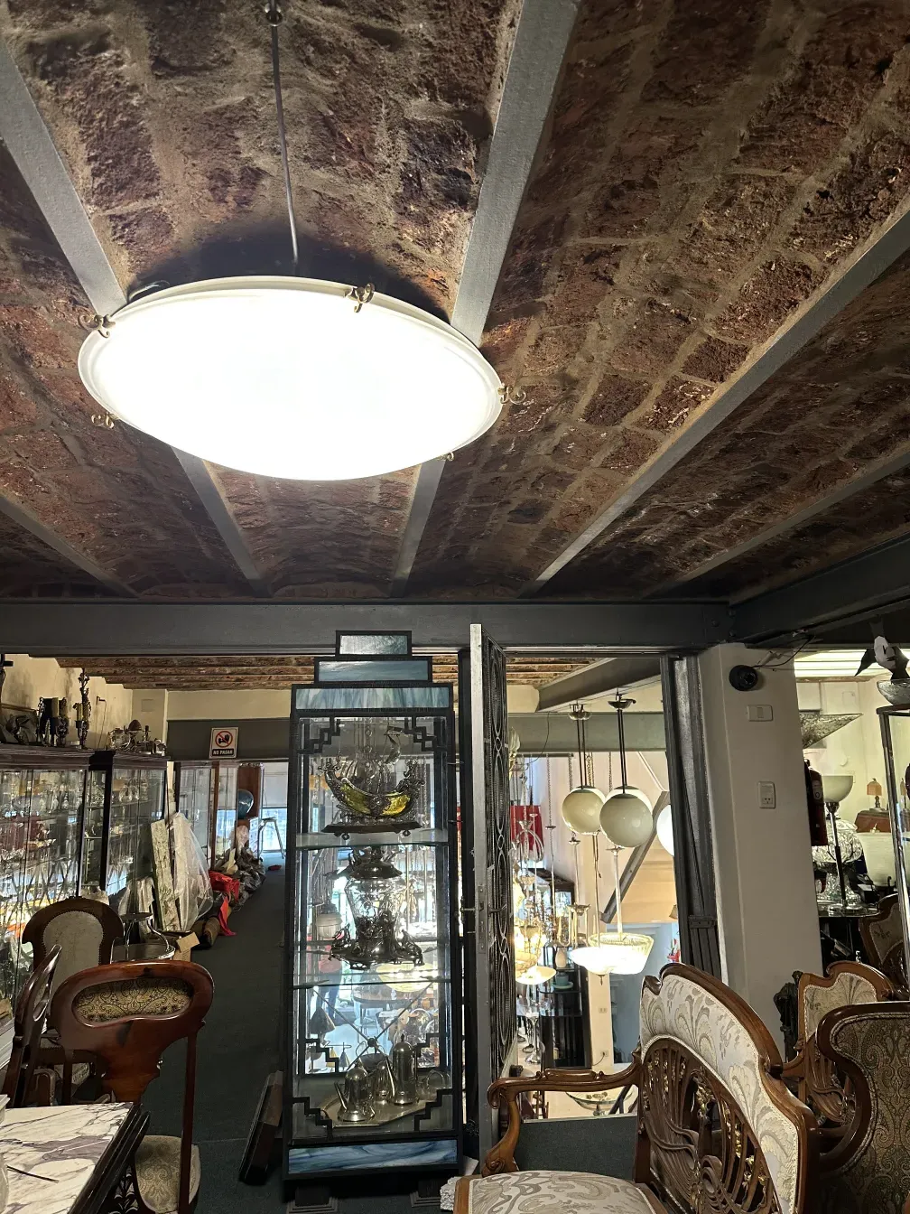 Four vintage ceiling lights in a shop with various decor.