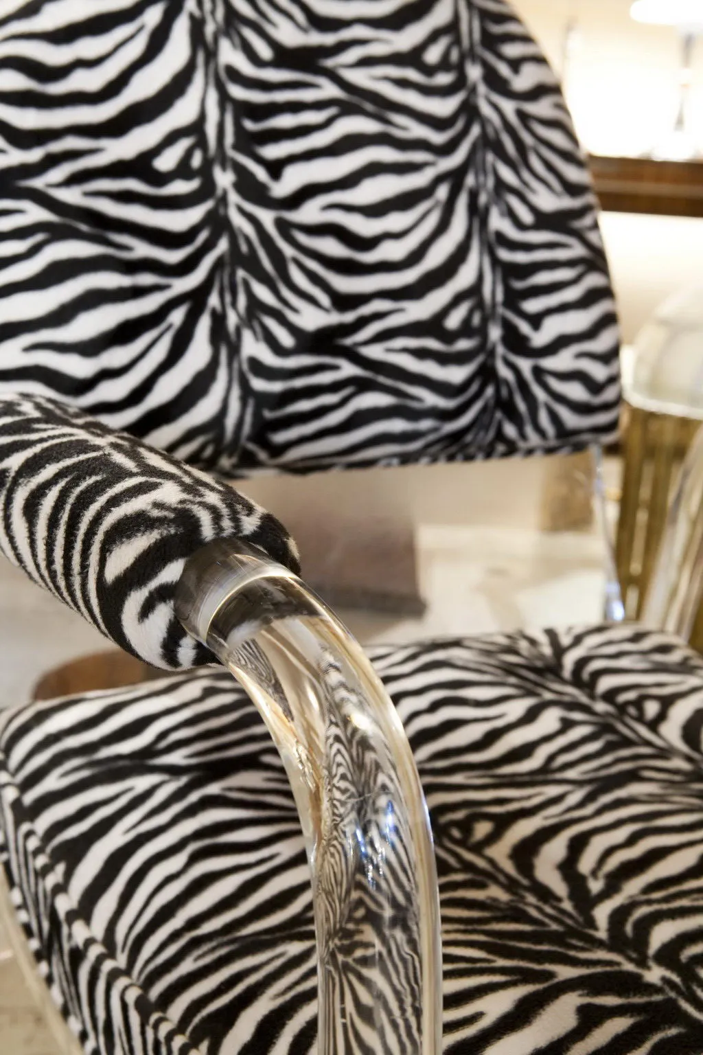 Detailed view of two antique armchairs with zebra design, well-lit background.