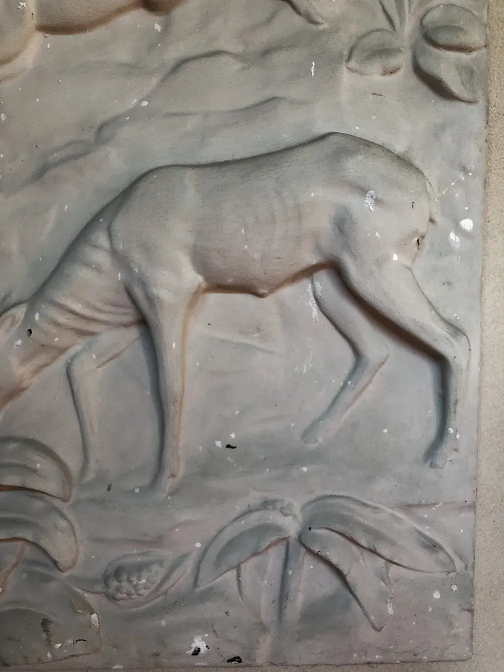 Placa de parede antiga com detalhes em relevo e decoração.