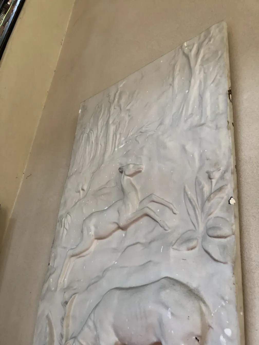 placa de parede antiga com relevo e formas de animais