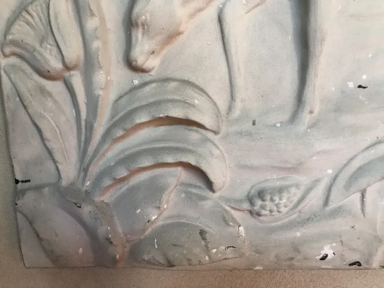 detalhe de uma placa de parede antiga com relevos de folhas e flores