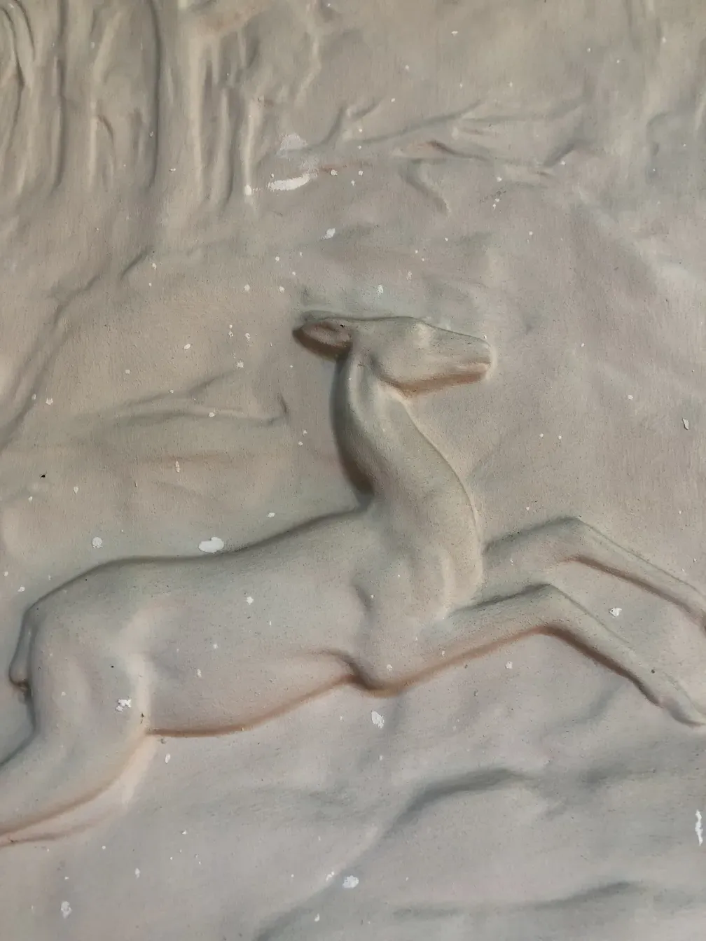 Placa de parede antiga com relevo, em cores suaves e decorações sutis em um ambiente etéreo.