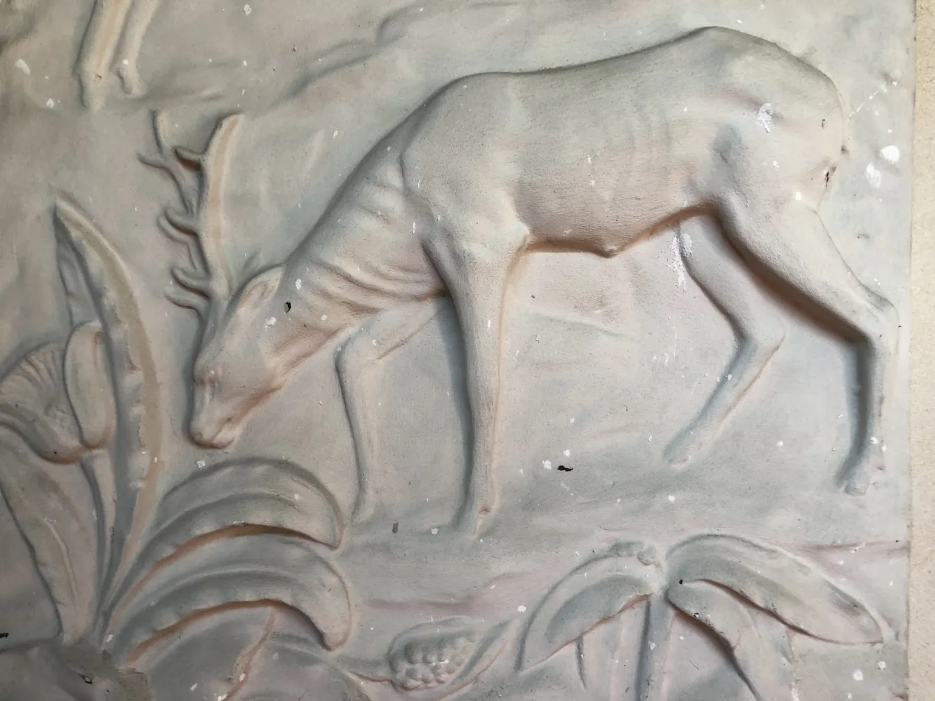 Placa de parede antiga com design de cervo e folhagem.