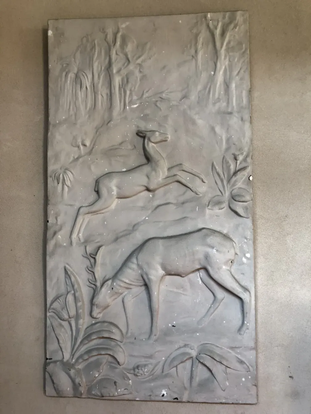 placa de parede antiga com relevos de um cervo e um coelho