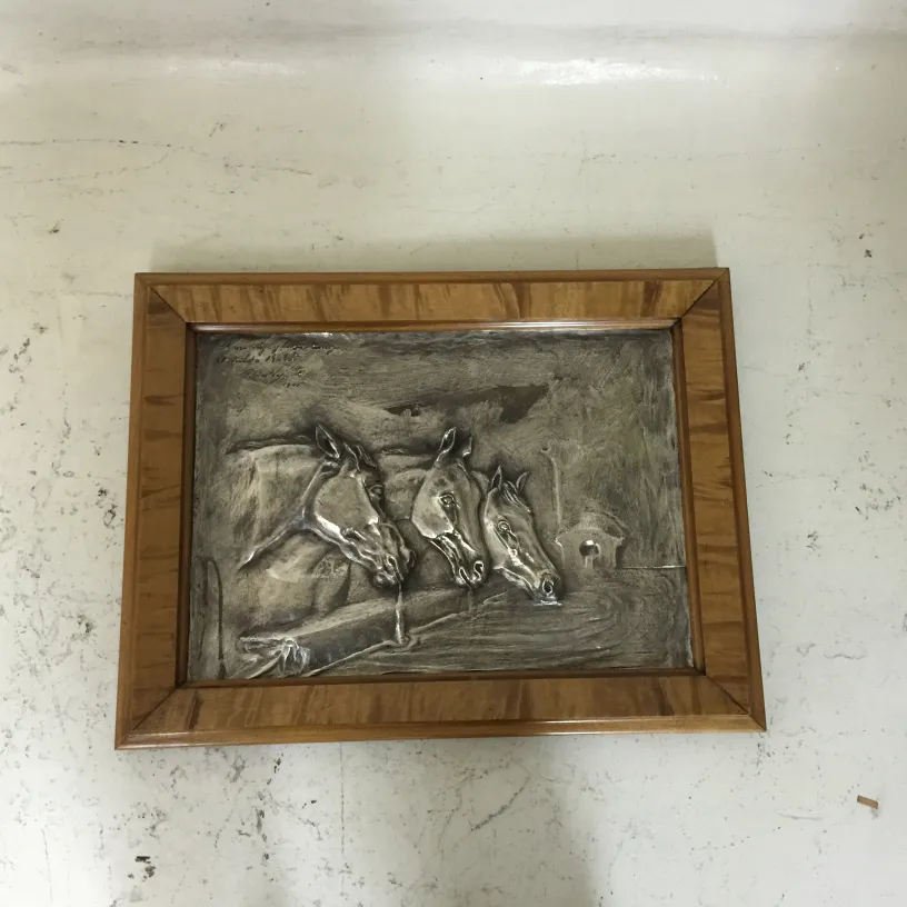 placa de parede antiga com relevo de cavalos em ambiente rústico