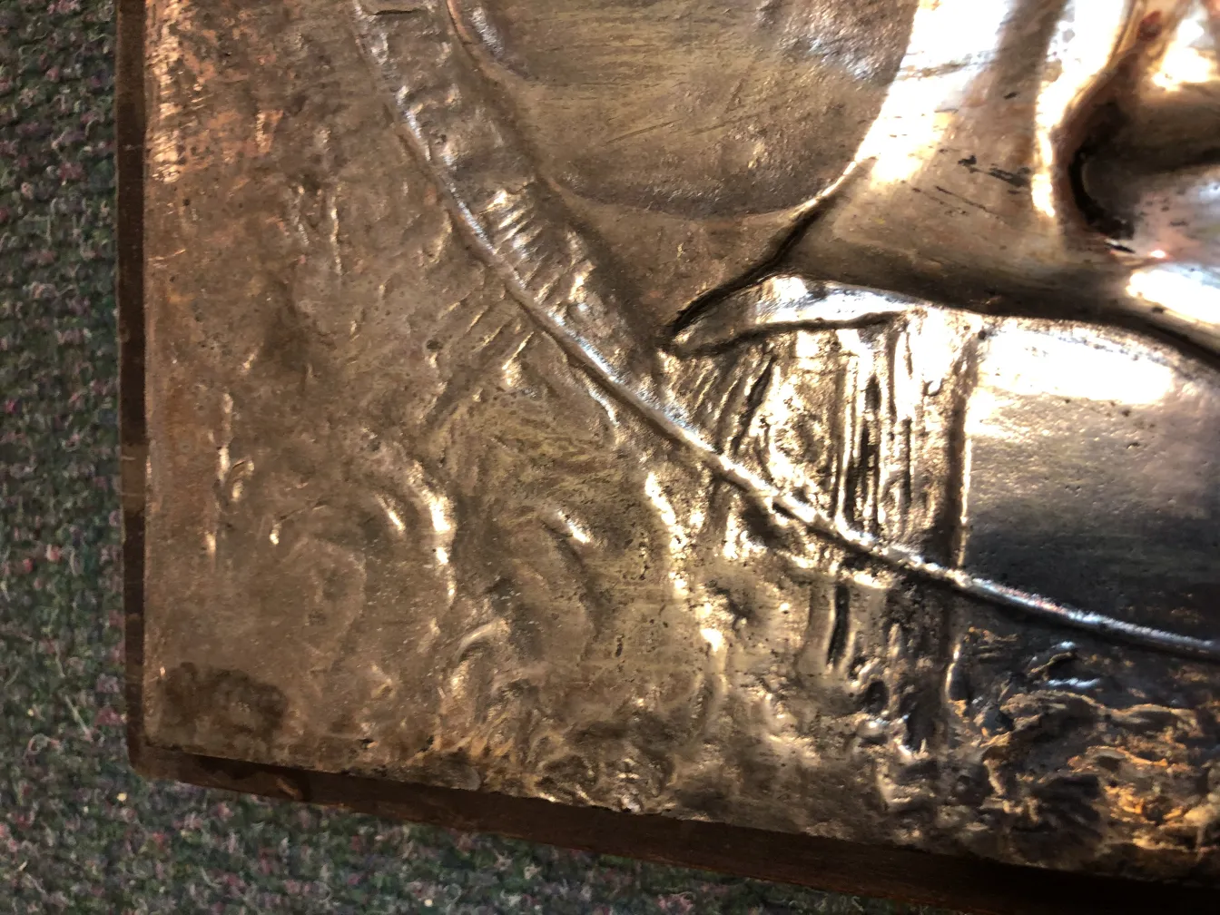 Placa de parede antiga com relevo, apresentando elementos decorativos sutis