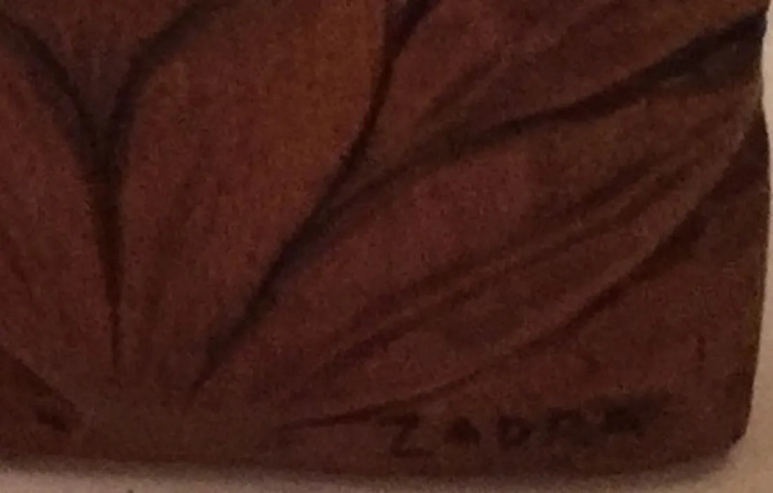 Placa de parede antiga com detalhes decorativos em um ambiente acolhedor.