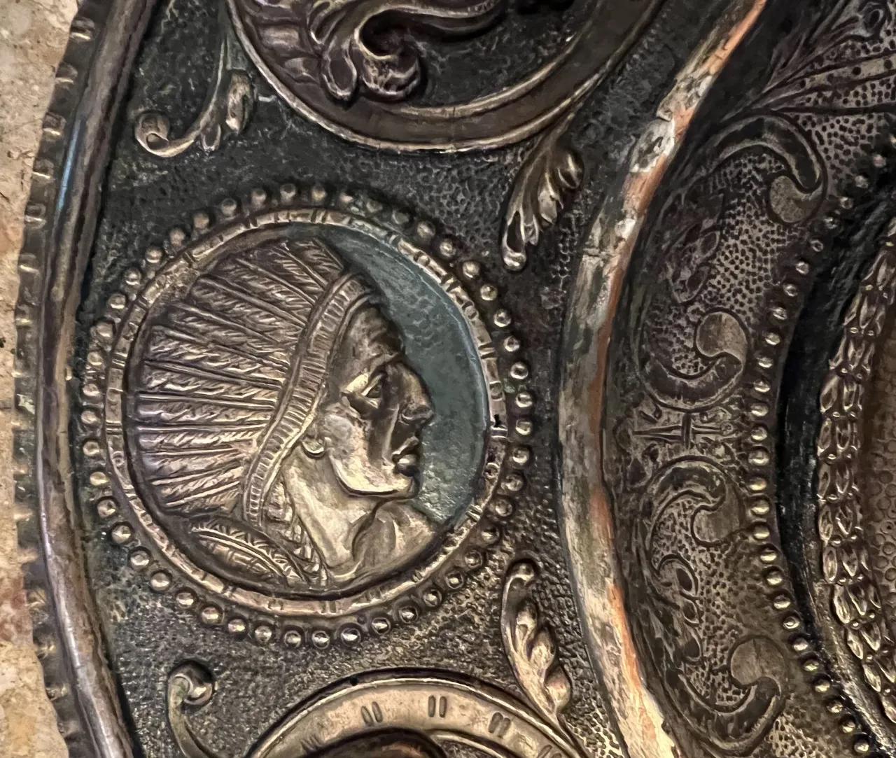 Antique wall plate featuring a relief of a human figure in profile