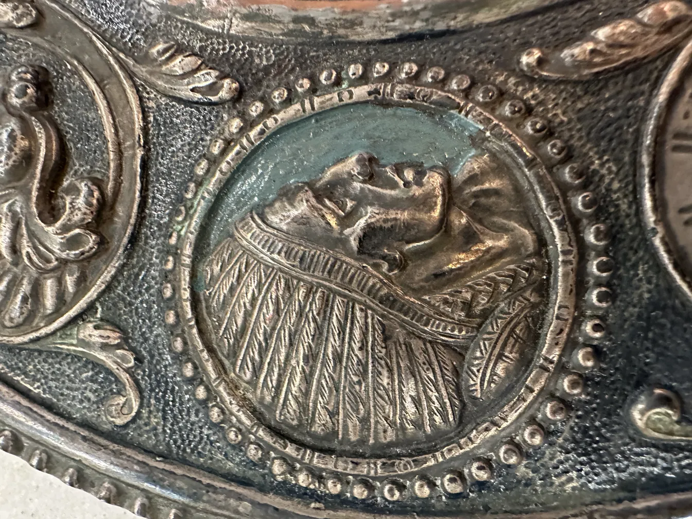 Antique wall plate featuring detailed reliefs and decorations.