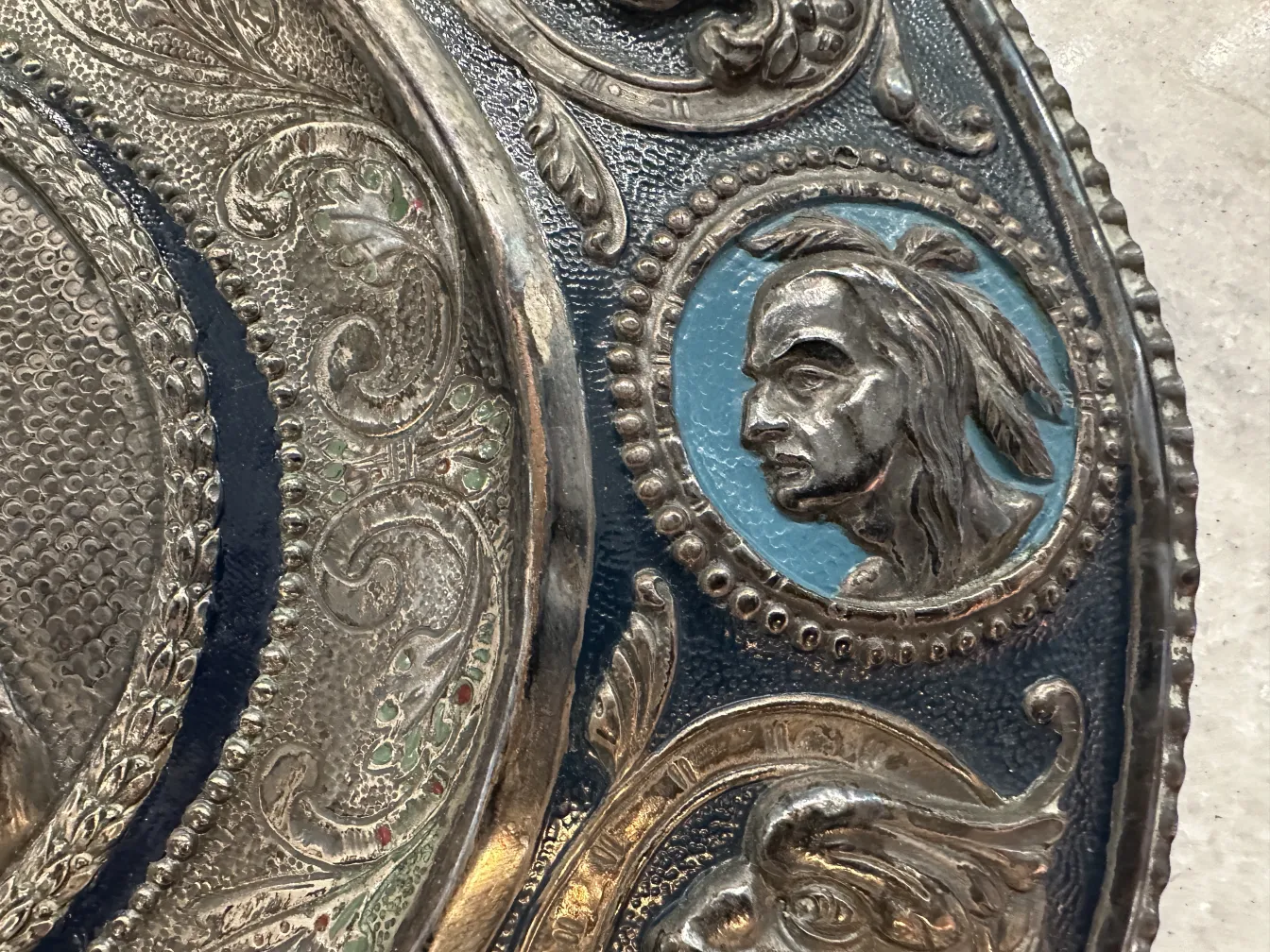 antique wall plate decorated with reliefs and a face image