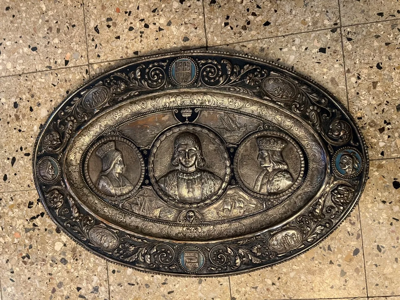 antique wall plate with embossed portraits and decorative background