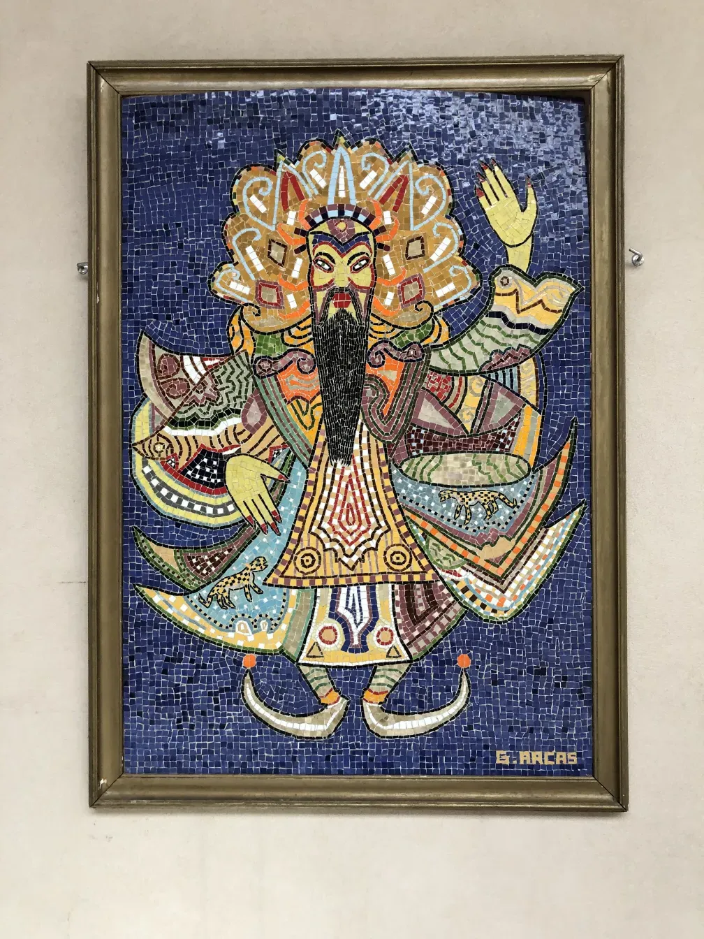 Quadro antigo de mosaico com design colorido e vibrante em fundo azul.