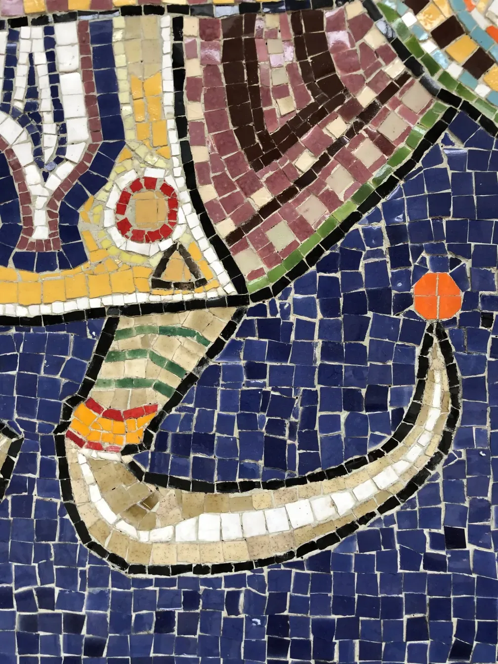 Quadro de mosaico antigo colorido com formas diversas em tons vibrantes.