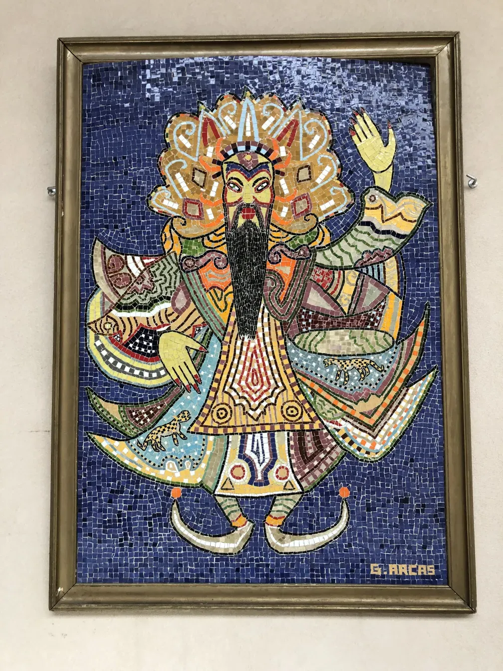 Quadro de mosaico antigo com cores vibrantes sobre fundo azul.