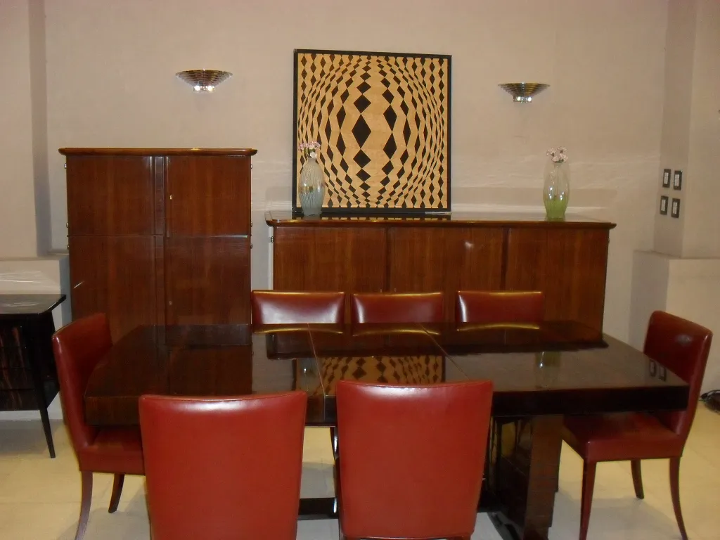 Mesa de jantar com cadeiras vermelhas e arte antiga em marchetaria