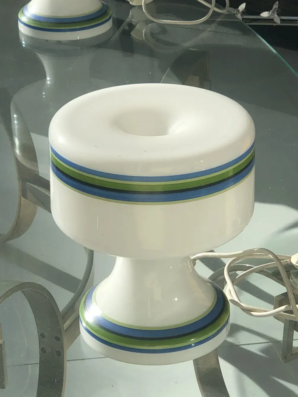 duas lâmpadas de mesa antigas com detalhes coloridos em um ambiente moderno.