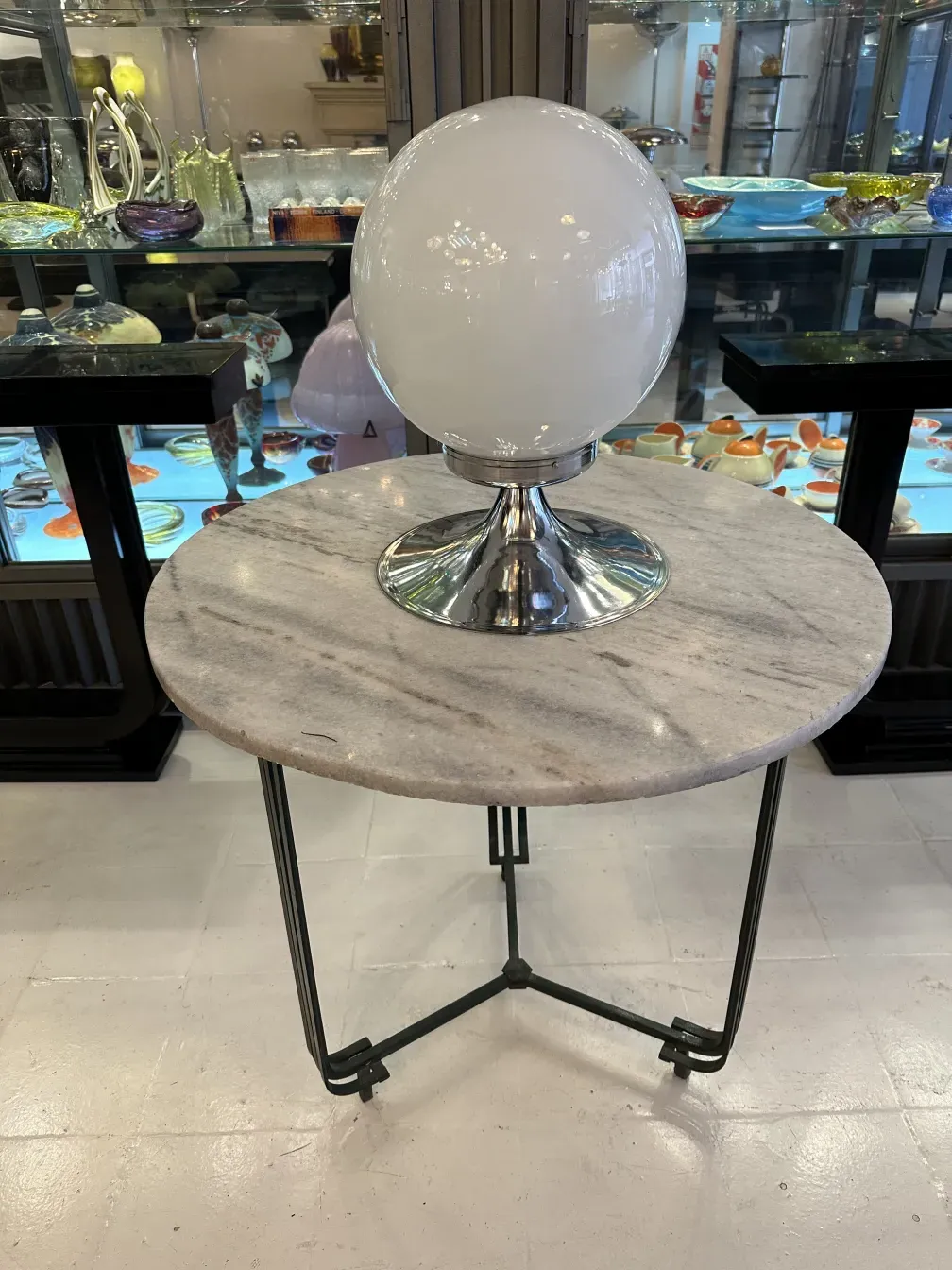 Duas lâmpadas de mesa antigas com bulbos esféricos e bases brilhantes em um ambiente elegante.