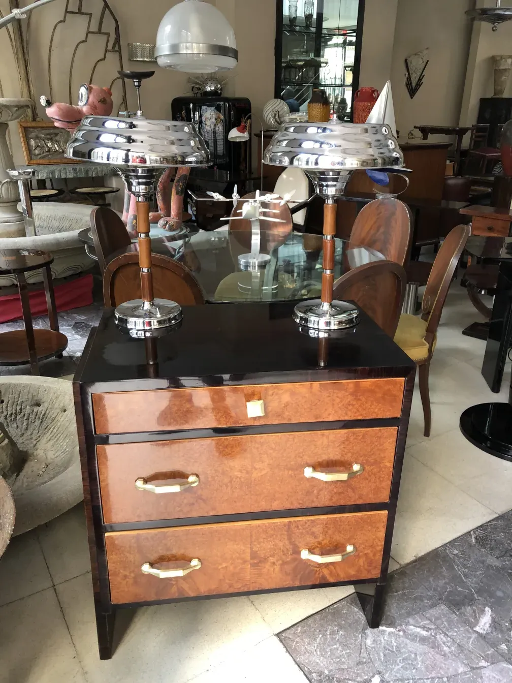 Duas lâmpadas de mesa antigas com design elegante, cercadas por vários móveis.