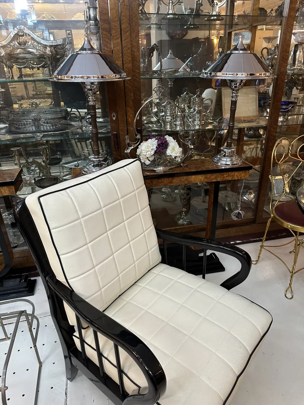 duas lâmpadas de mesa antigas com uma cadeira branca ao fundo