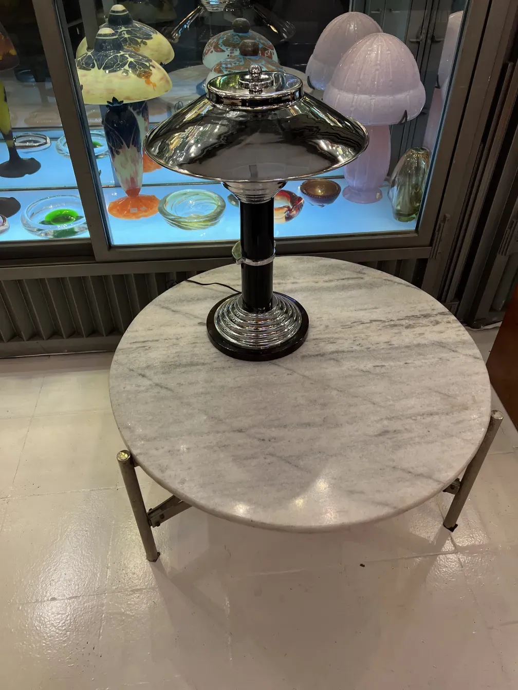 duas lâmpadas de mesa antigas em uma exibição de vidro