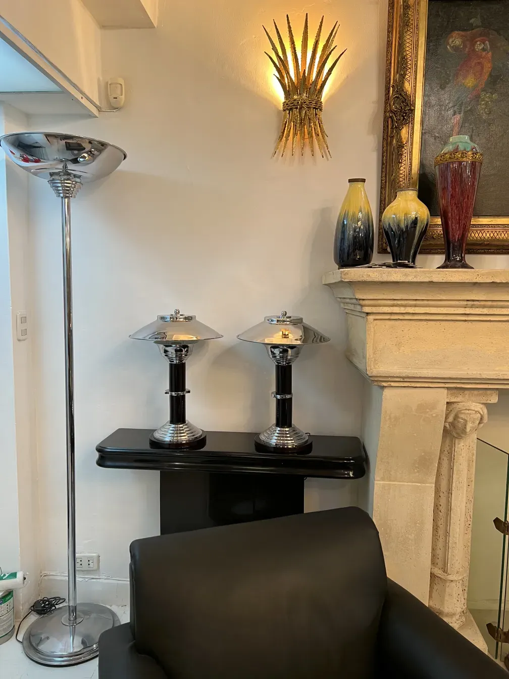 duas lâmpadas de mesa antigas com detalhes brilhantes e forma elegante, cercadas por várias decorações.