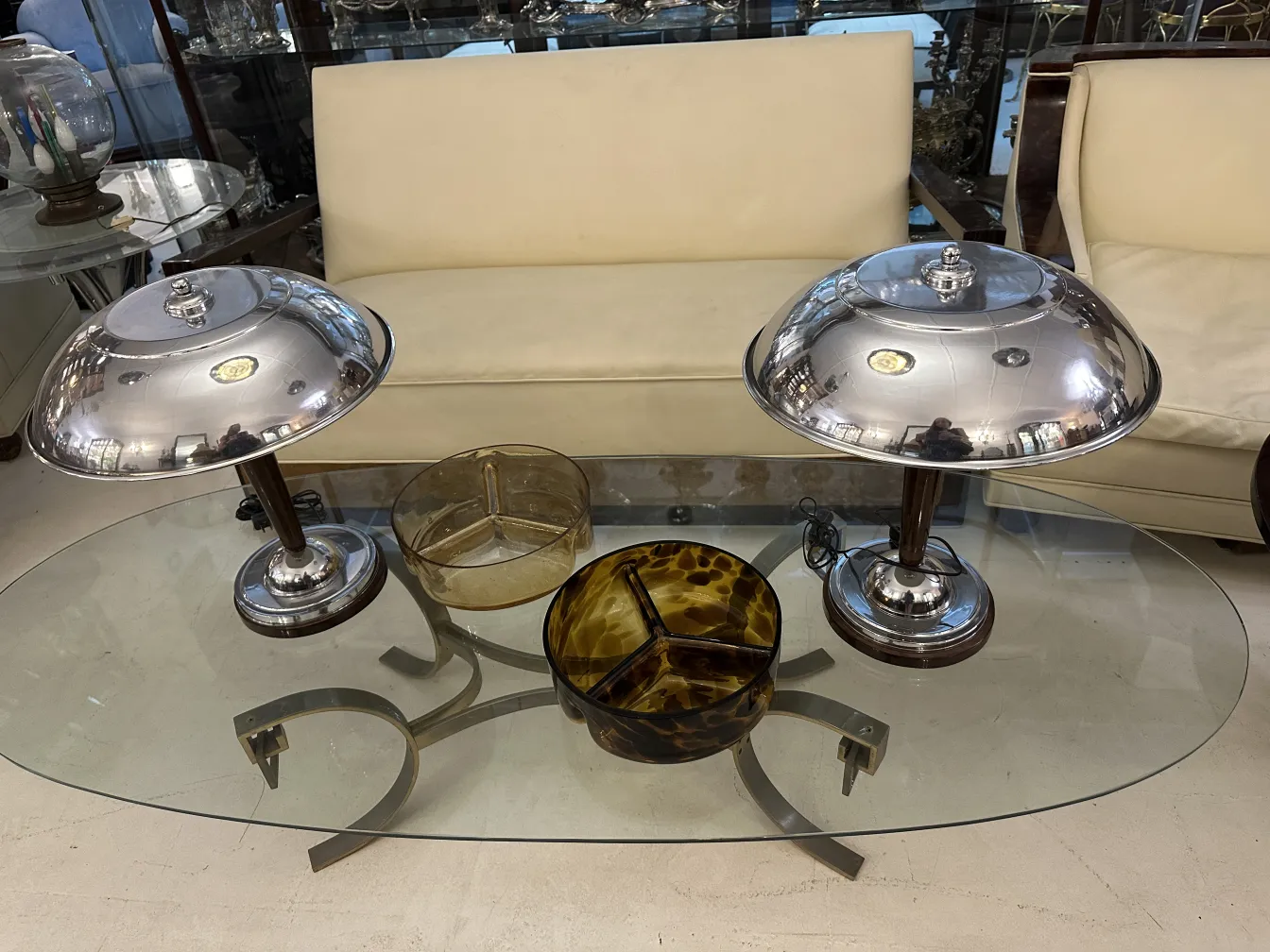 2 lampadas de mesa antigas sobre mesa de vidro com decorações