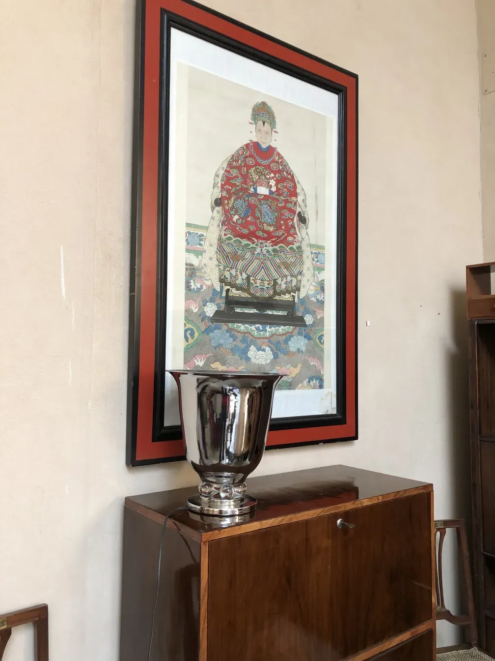 Duas lâmpadas de mesa antigas com design elegante, em um ambiente aconchegante com obras de arte ao fundo.