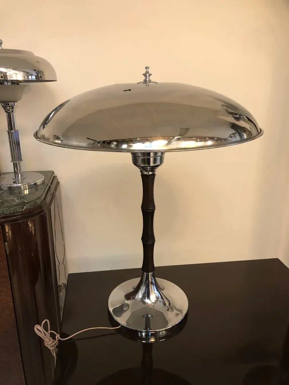 2 lampadas de mesa antigas com base metálica e tela brilhante, ambiente elegante.