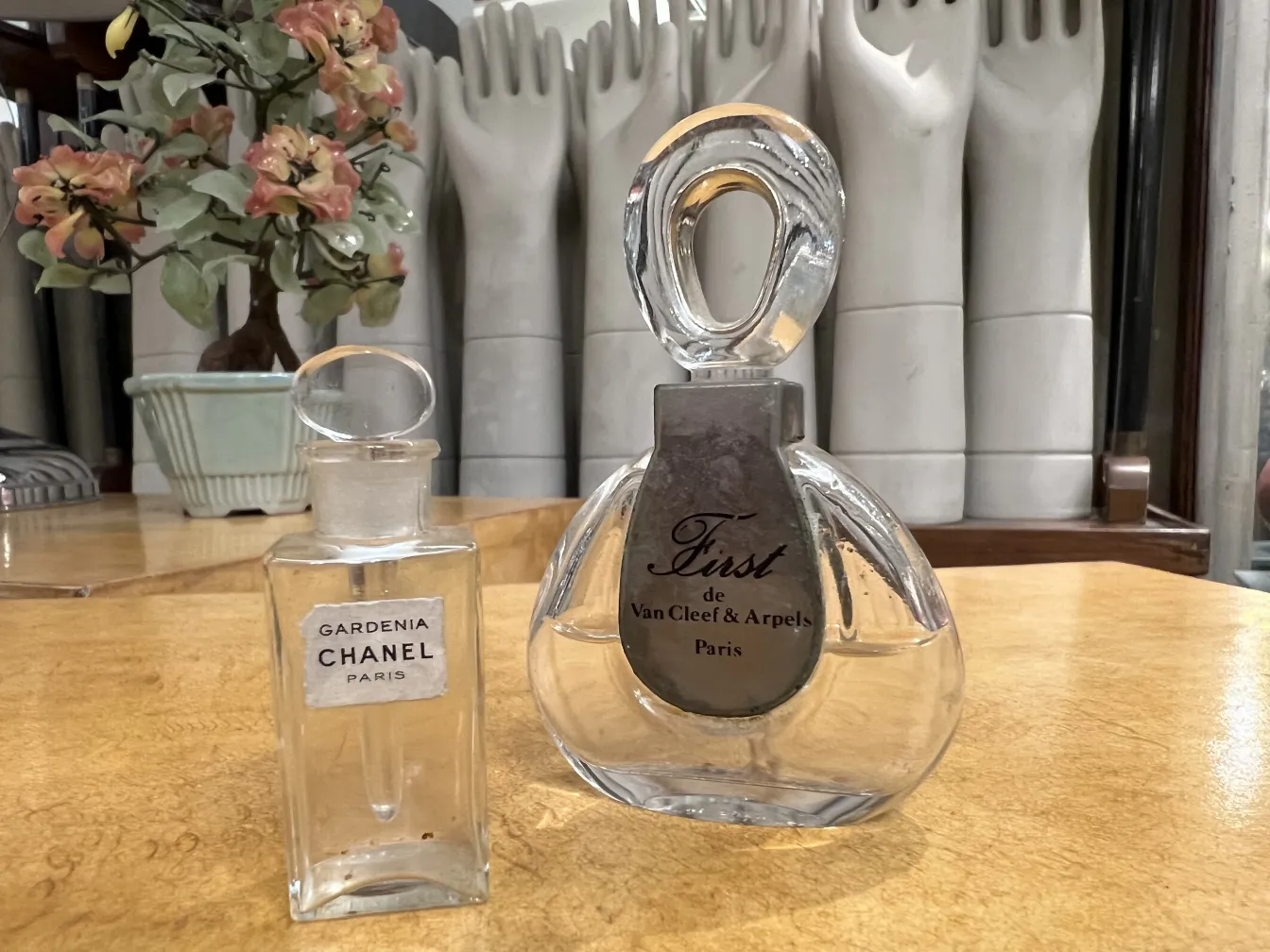 Античный флакон для духов Gardenia от Chanel, элегантный и отличный, с декоративным цветком на заднем плане.