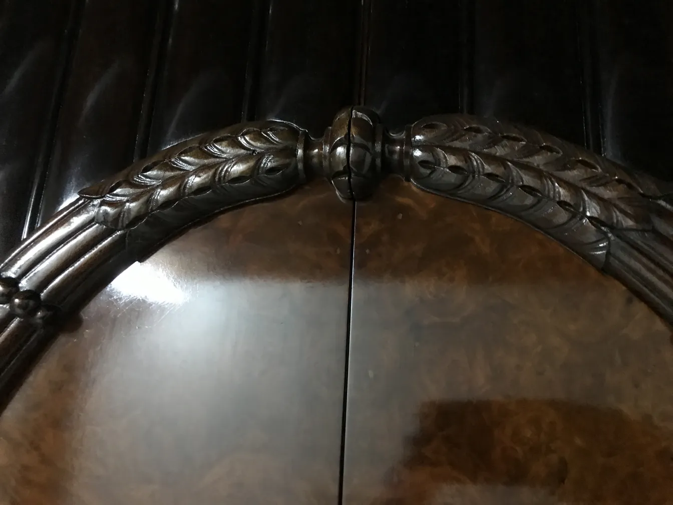 antique display cabinet with ornate details on top