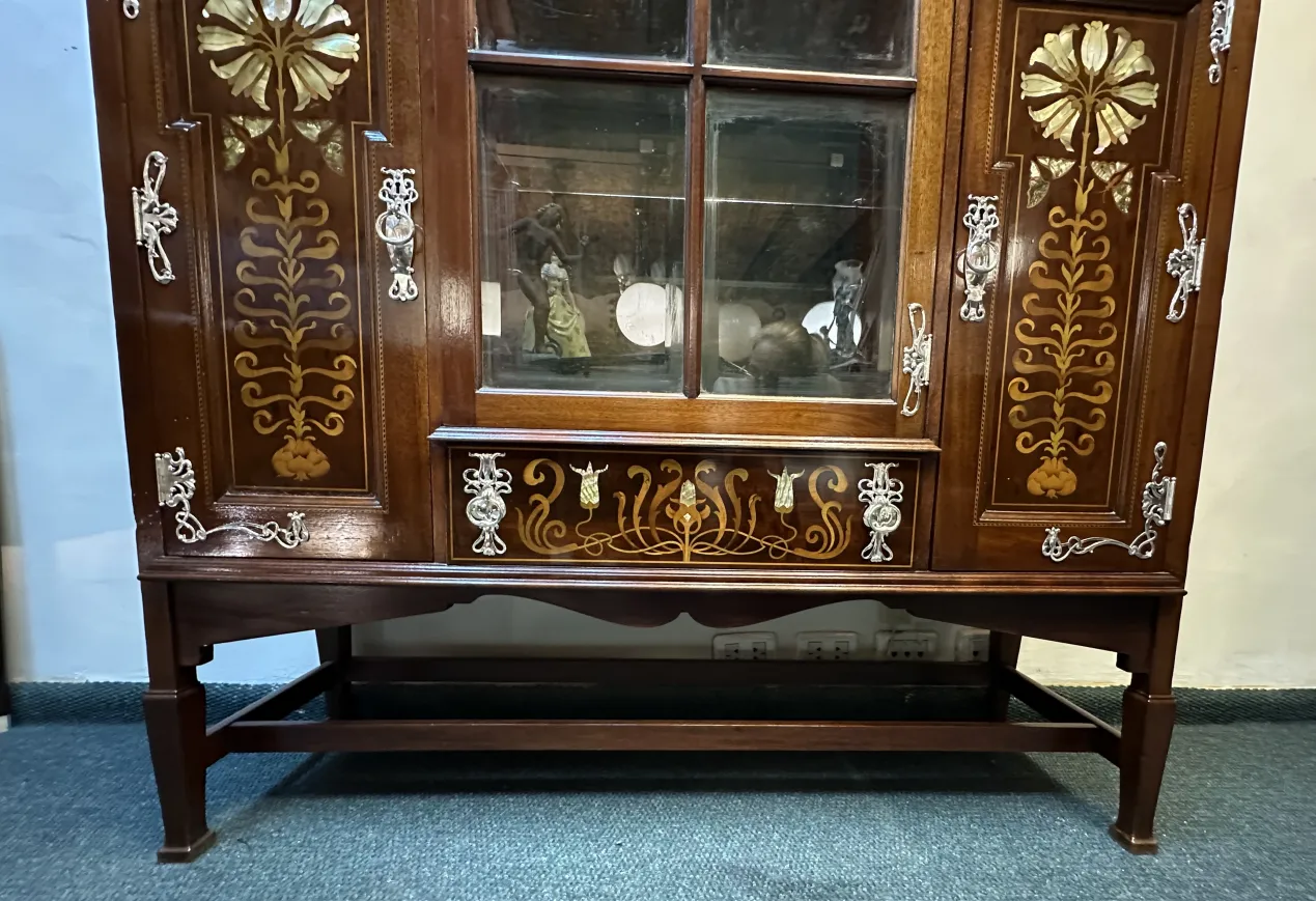 antique display cabinet with decorative details and figures