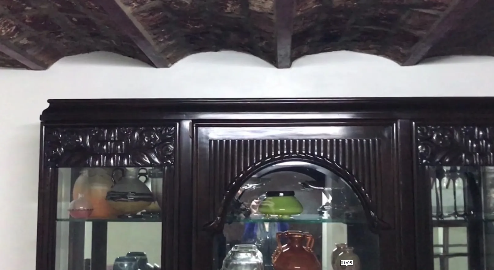 Antique display cabinet with intricate decorations and various displayed items.