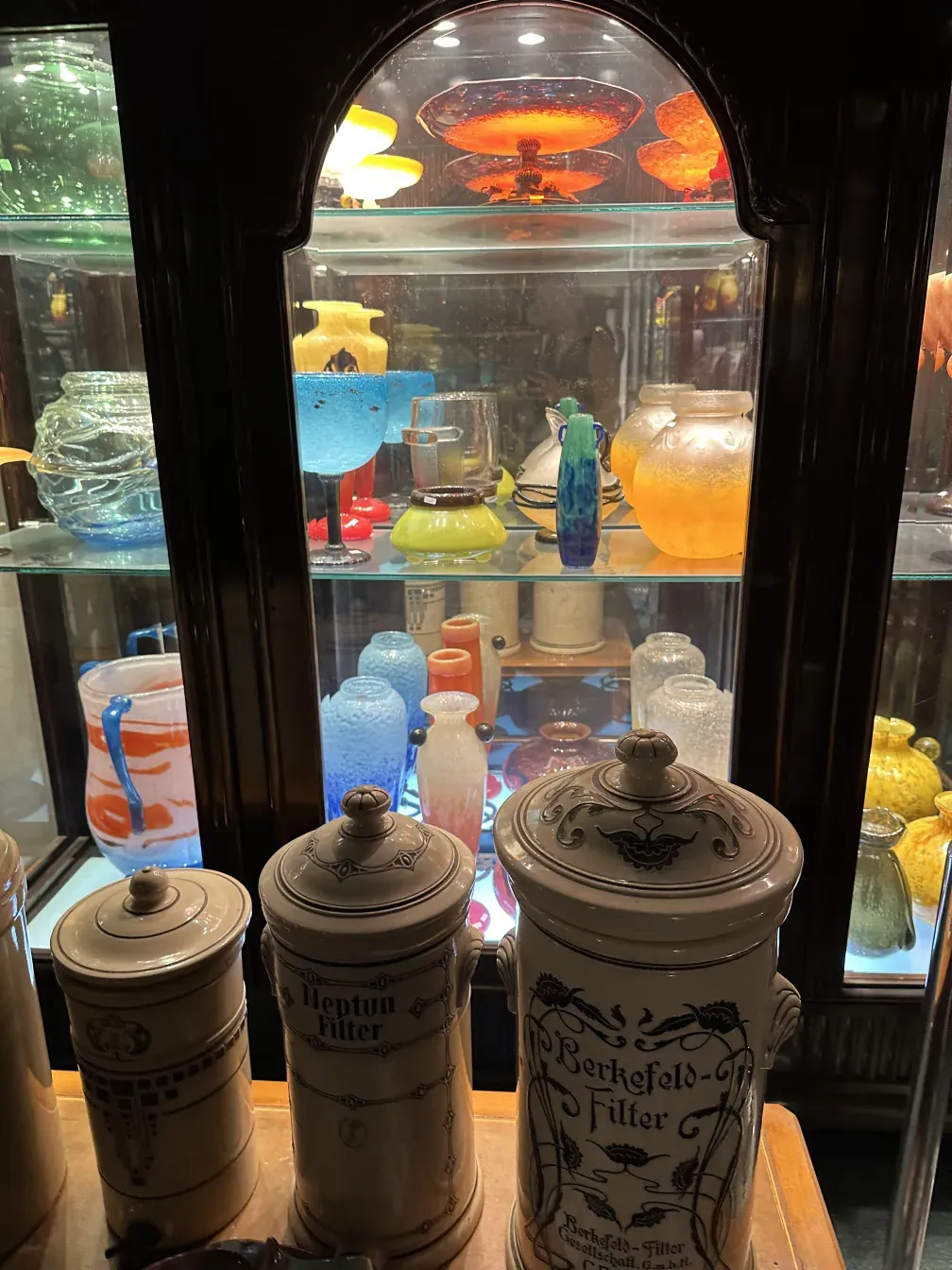 Antique display cabinet with various colorful items inside