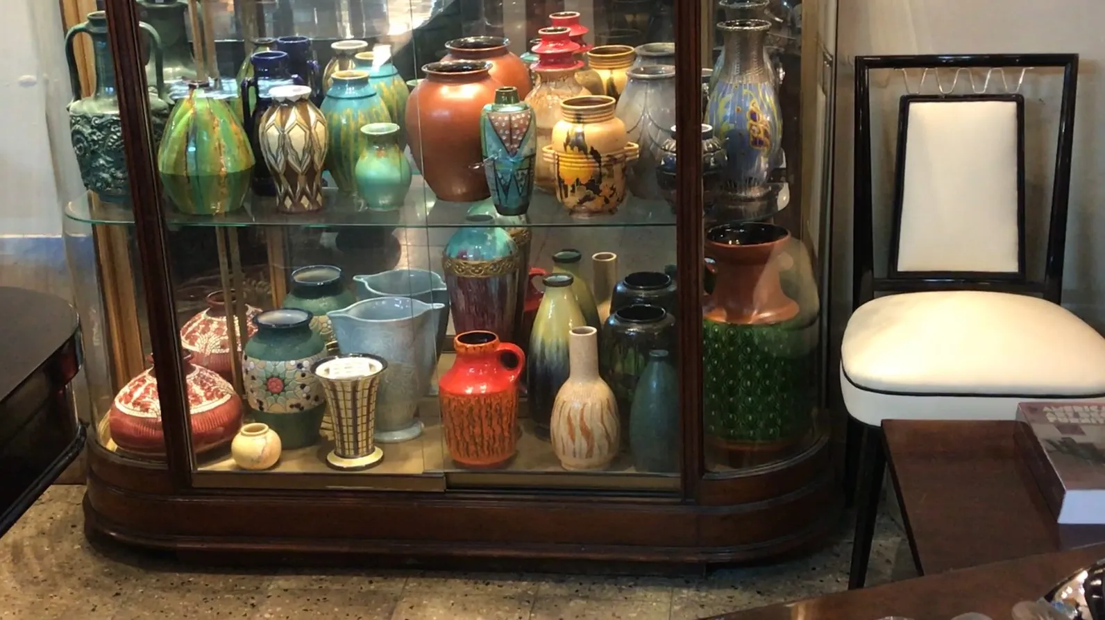 old display cabinet with vases in various colors and shapes