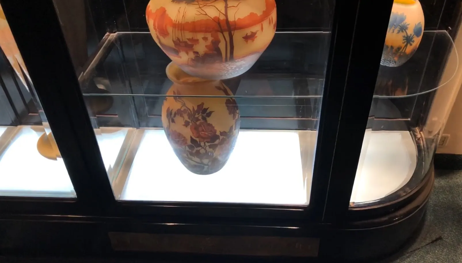 Antique display cabinet featuring various internal decorations and illuminated background