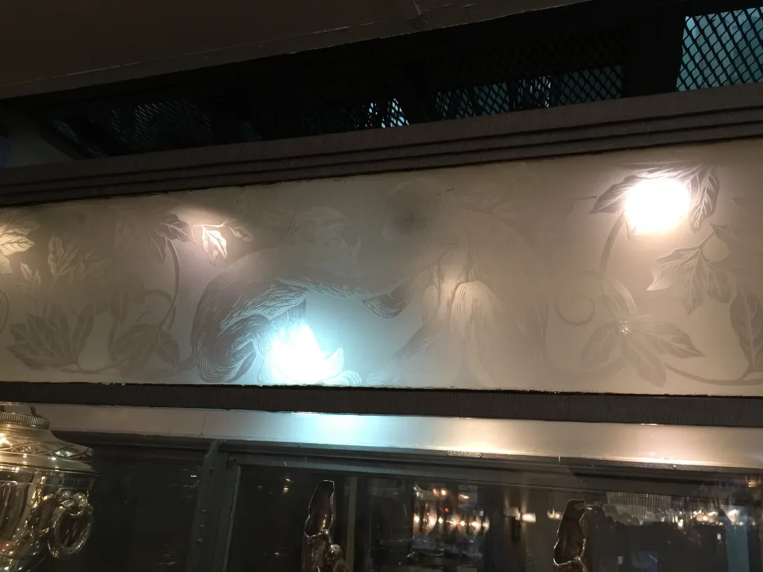 antique display cabinet with floral design at the top illuminated