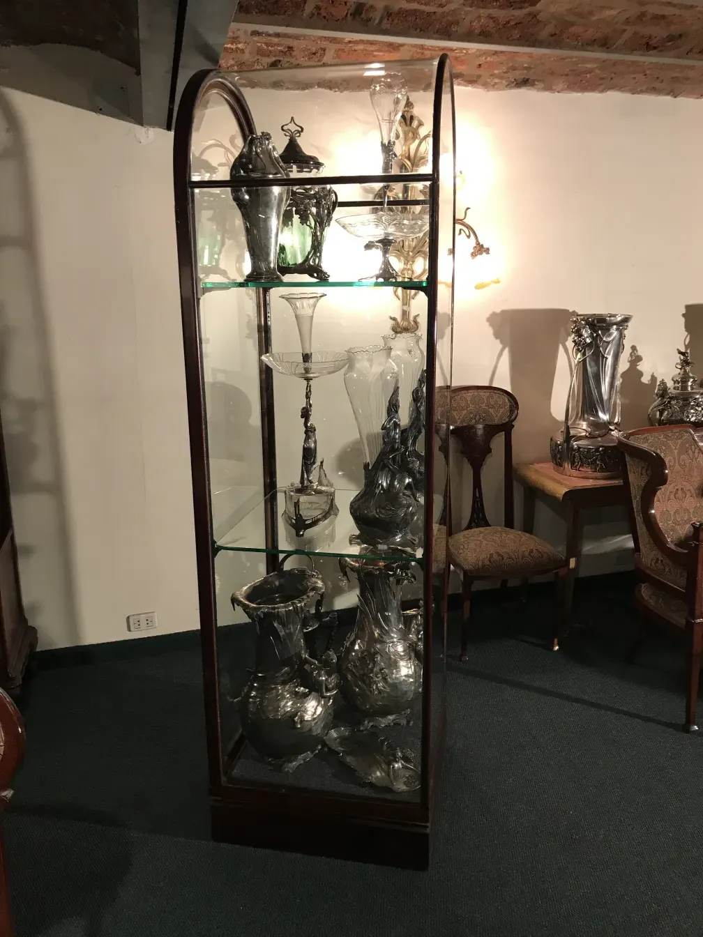 Antique display cabinet showcasing decorative items, soft lighting and elegant background