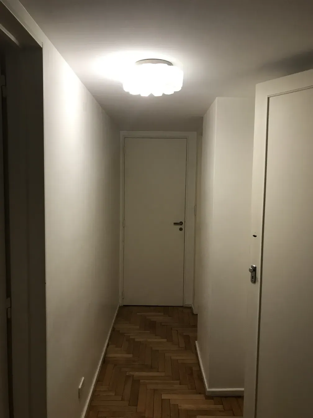 Antique ceiling light illuminating a neutral space