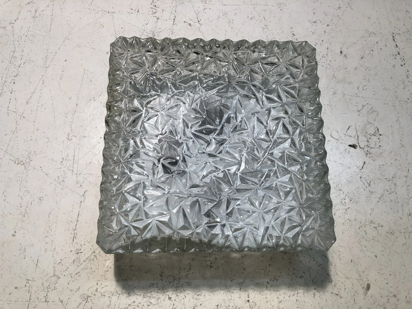 antique glass ceiling light with decorative design, embossed figure, on a white surface