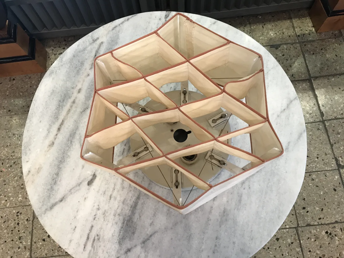 two antique ceiling lights with geometric design and visible structure, illuminated setting