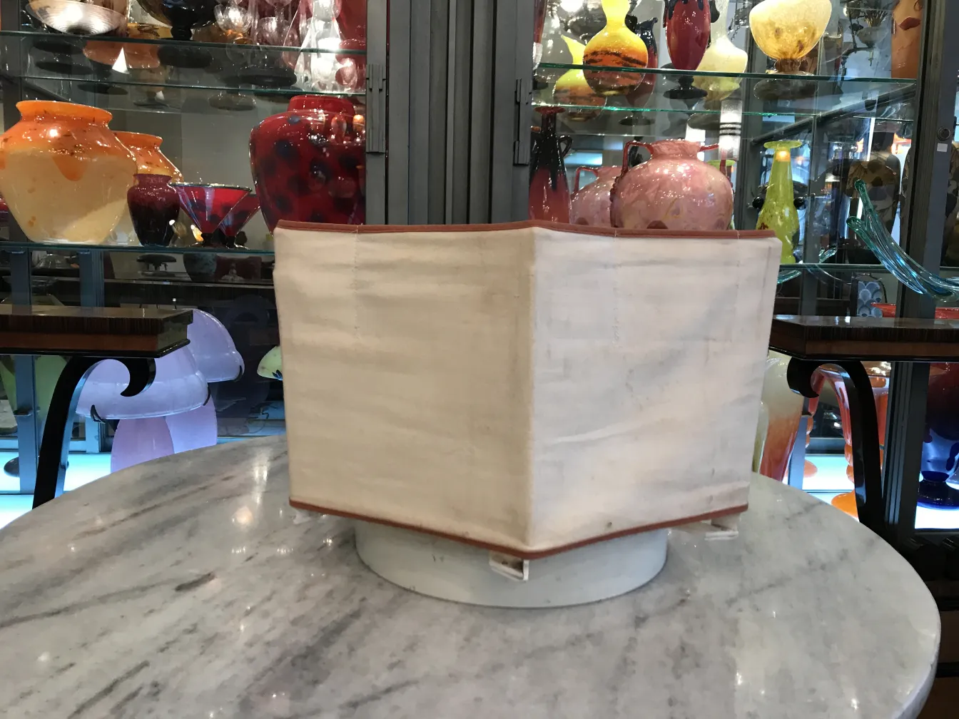 Two antique ceiling lights with a simple design, set among glass items