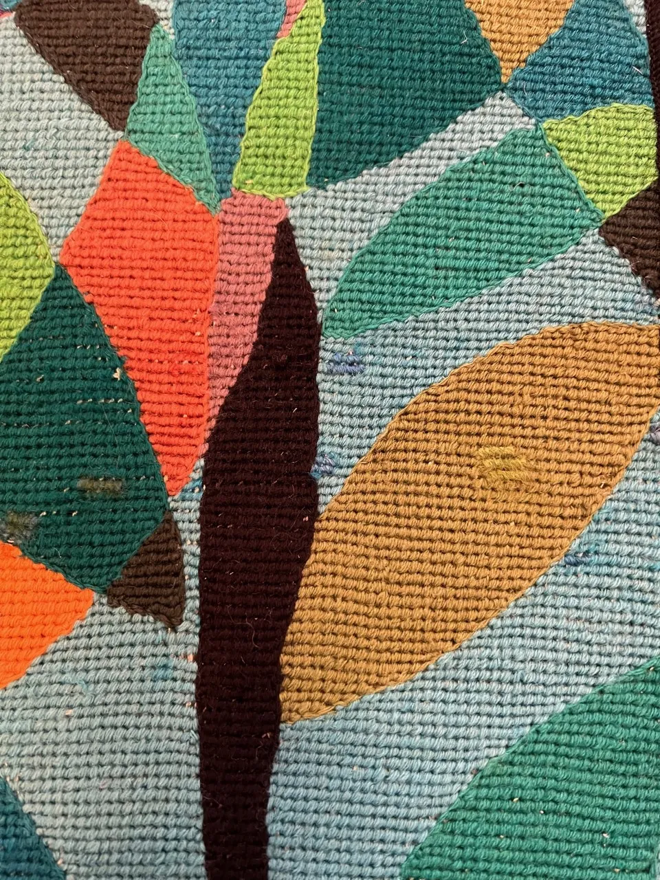 tapeçaria antiga com textura grossa, cores vibrantes e desenhos em forma de folhas