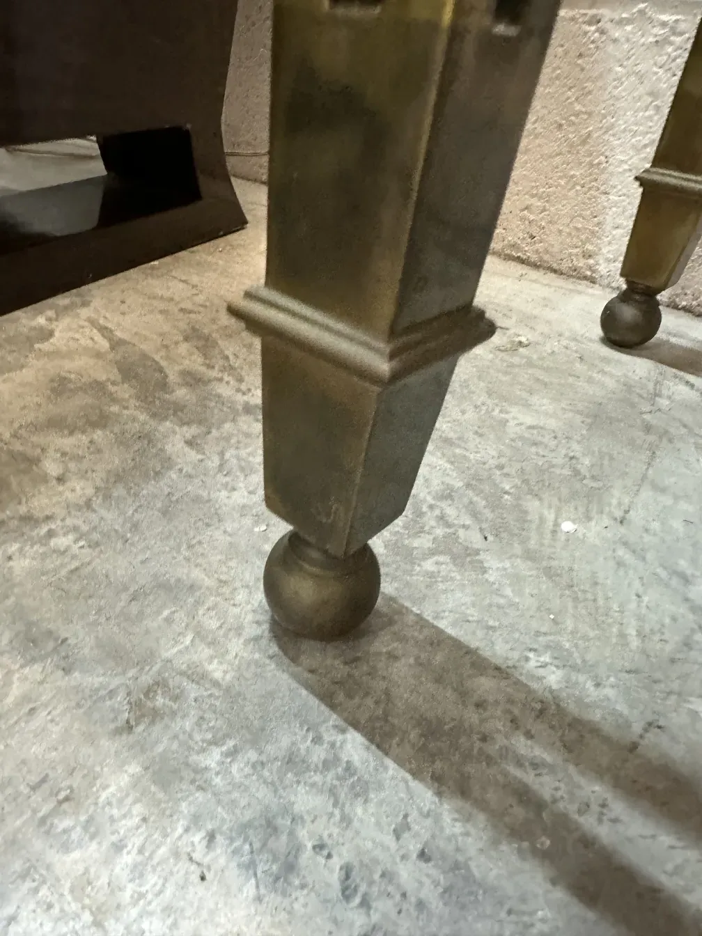 Antique console with design legs, concrete background.