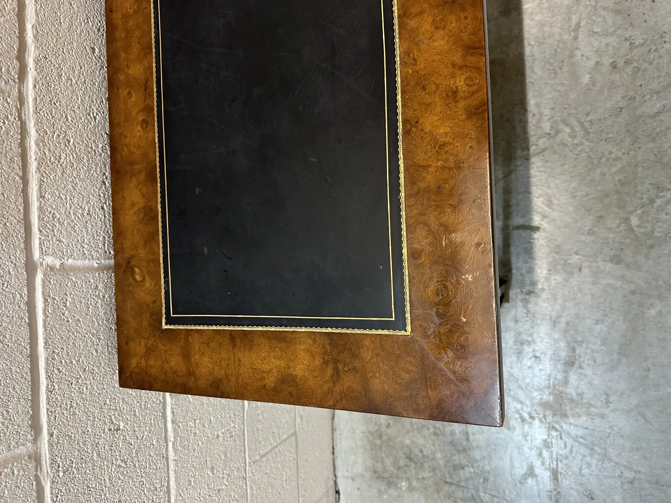 view of an antique console, featuring a black surface and gold detailing