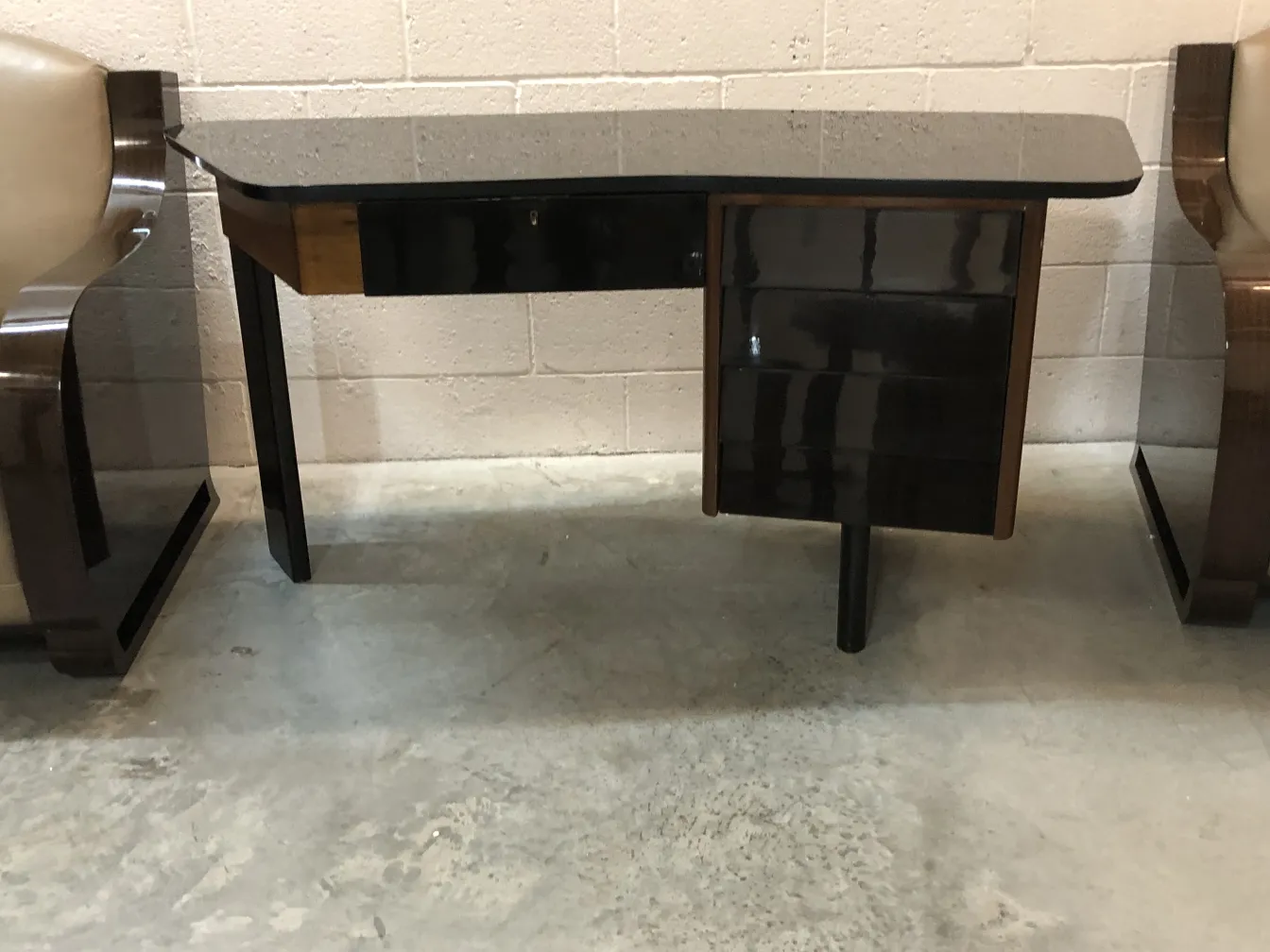 black antique desk with two drawers in a neutral setting