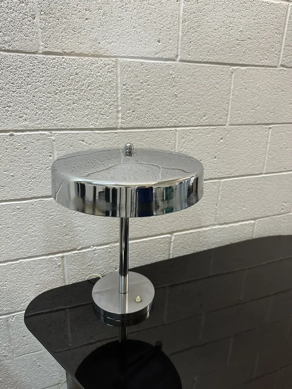 Antique table lamp with shiny finish in a neutral setting.